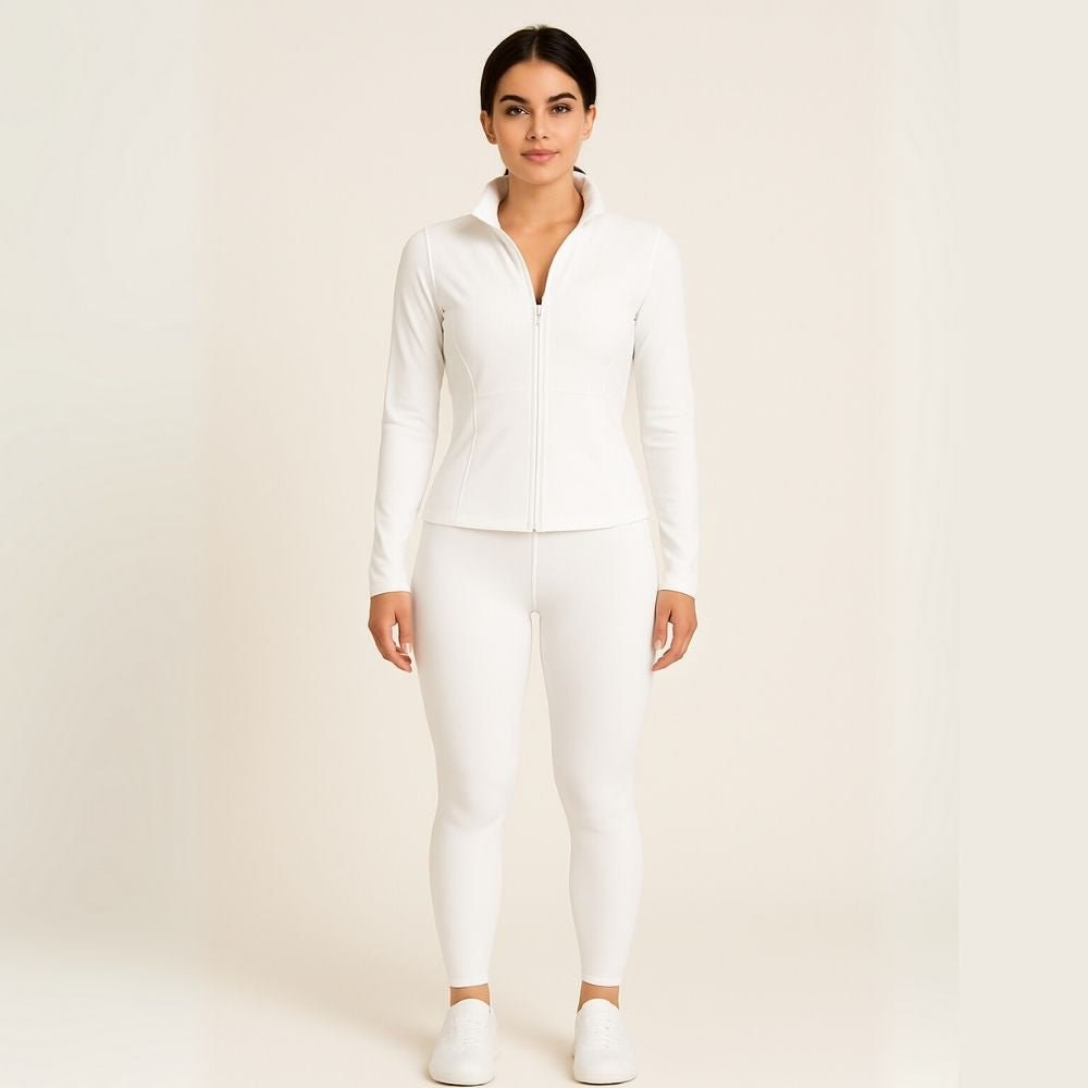 Model wearing the white Kouvr Sculpting Athletic Jacket in a modern fitness studio.