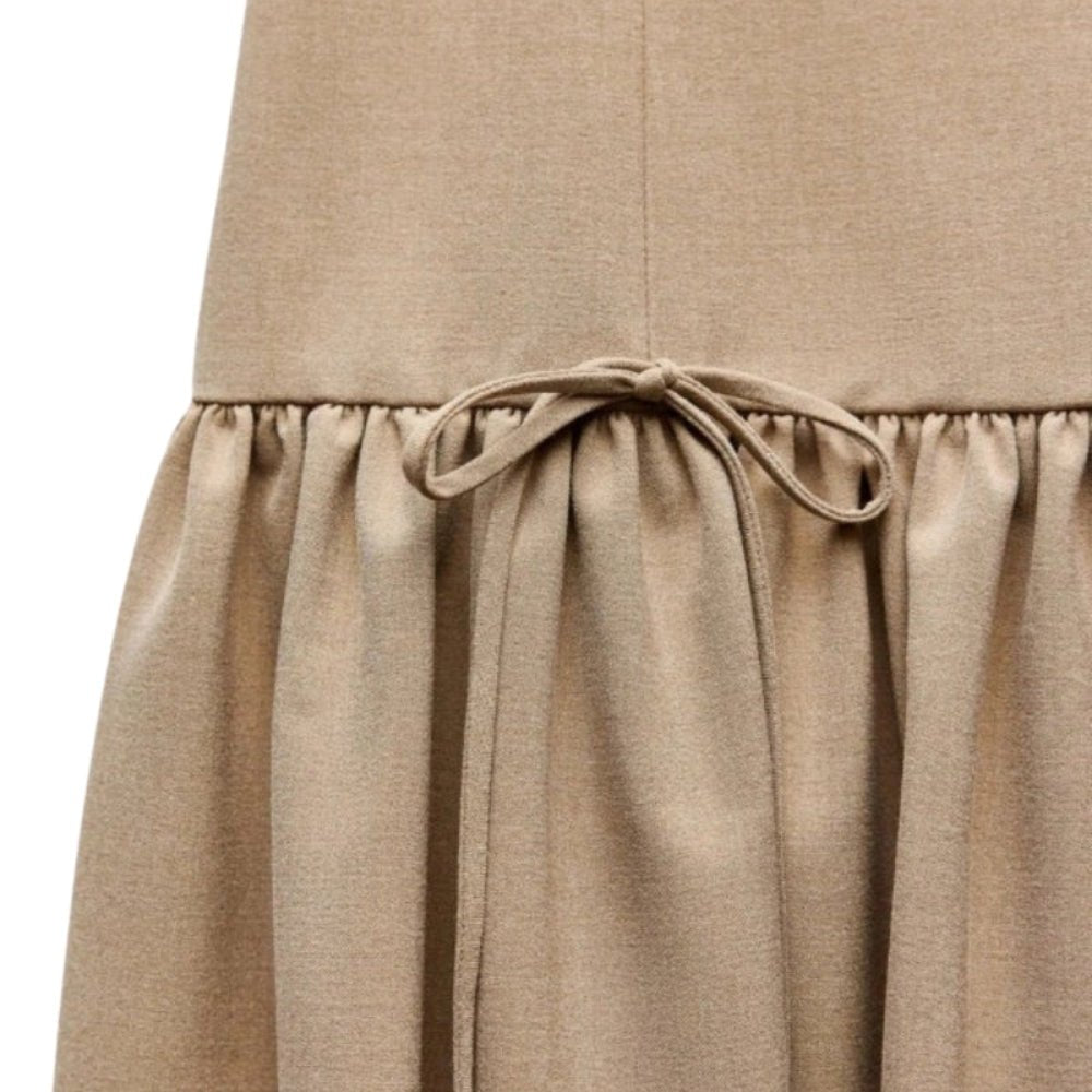 Close-up of a khaki Kouvr skirt with a tie waist on a white background