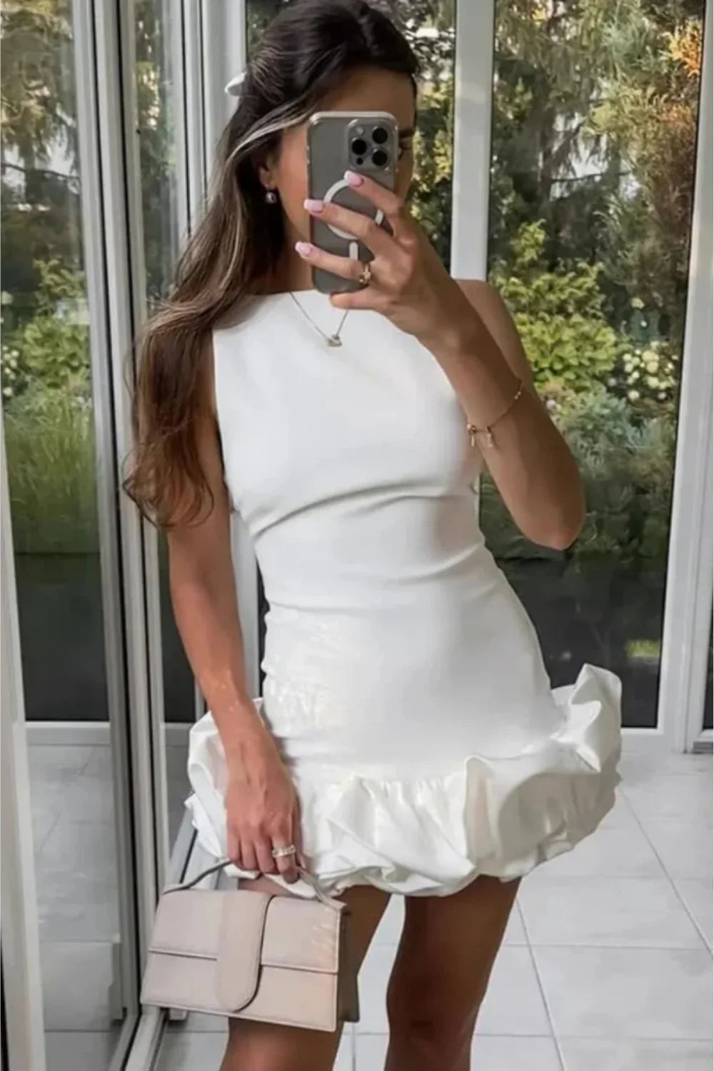 Model wearing Kouvr Fashion's white sleeveless bubble hem mini dress