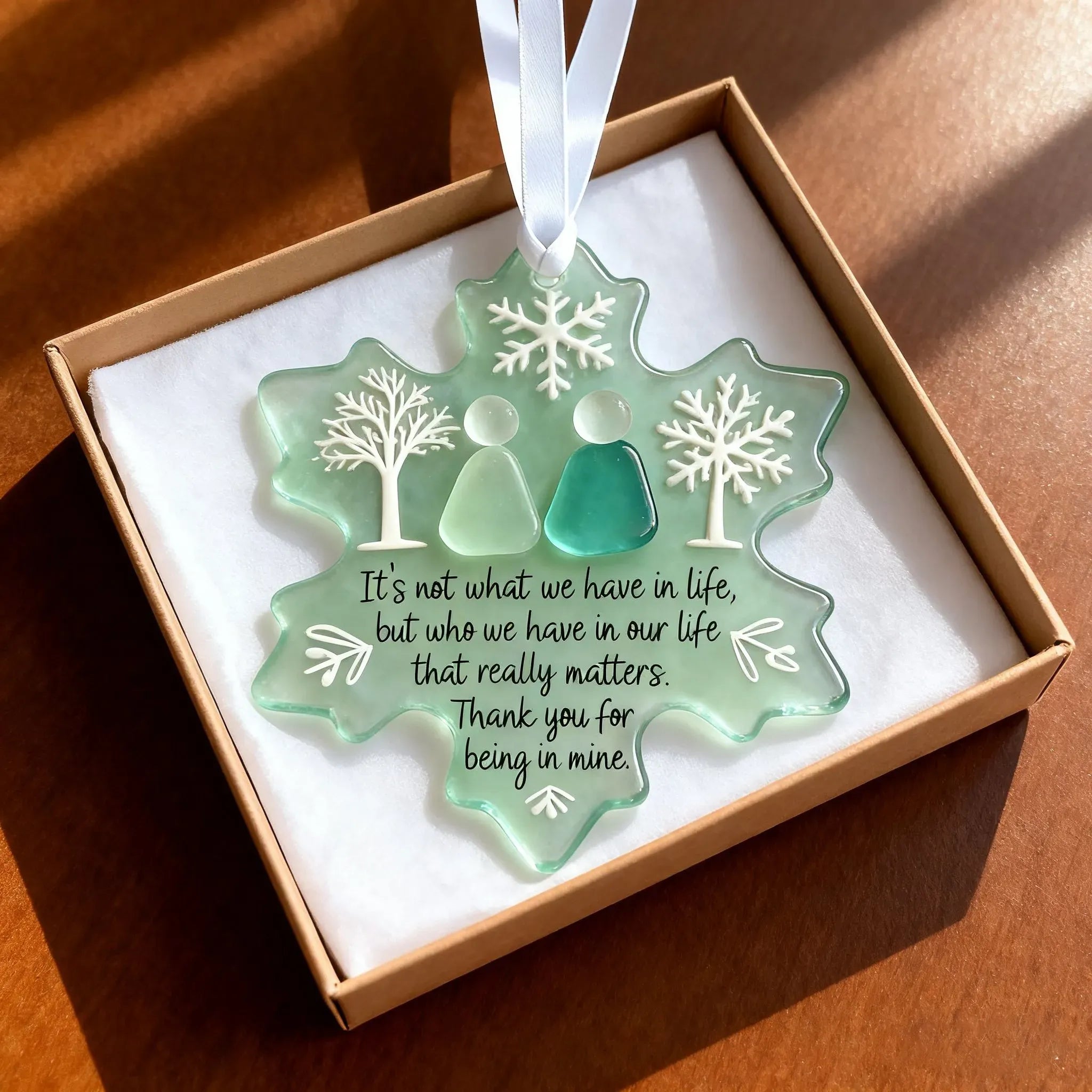 Kouvr's sea glass friendship ornament with a sentimental quote, presented in a brown gift box with a white ribbon.