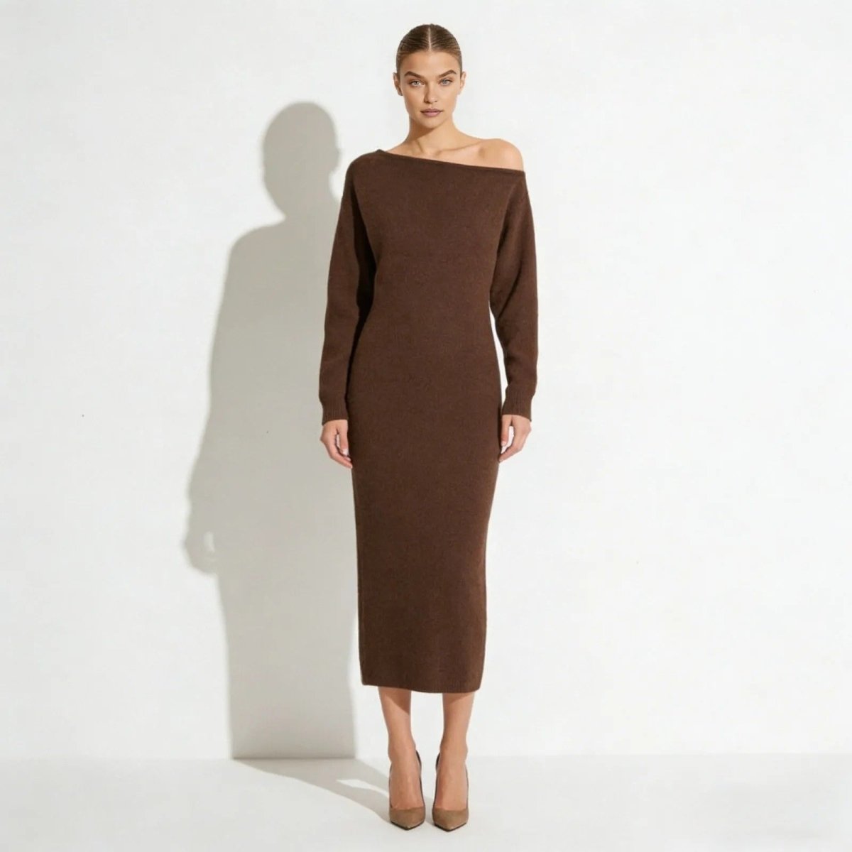 Model wearing the Selena off-the-shoulder long sleeve sweater dress in dark brown, showing the elegant asymmetrical neckline from the front.