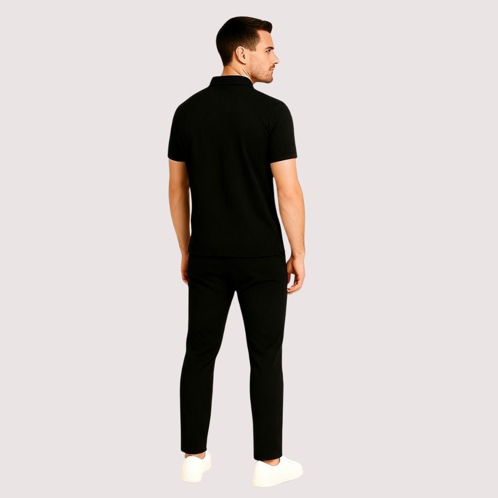 Man wearing the Kouvr Signature Black Polo Shirt with black trousers