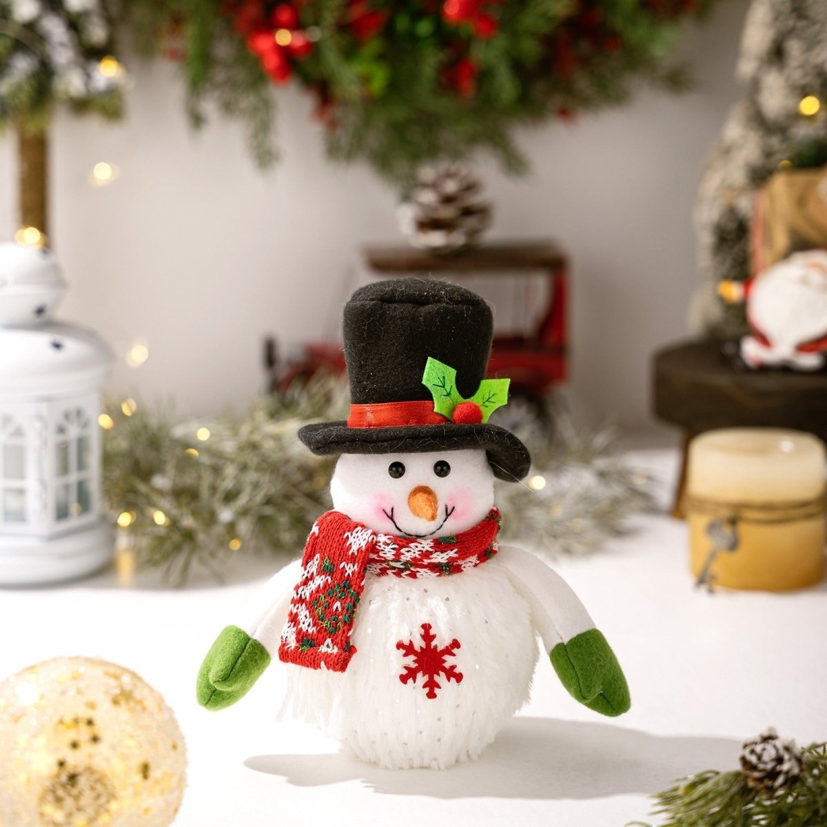 A close-up of the unlit Kouvr snowman figurine wearing a black top hat, red and white scarf, and green mittens, highlighting its cheerful expression.
