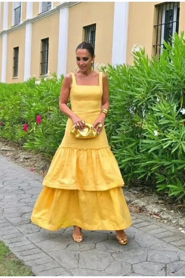 Model wearing the Kouvr Valeria canary yellow tiered ruffle maxi dress at an outdoor event