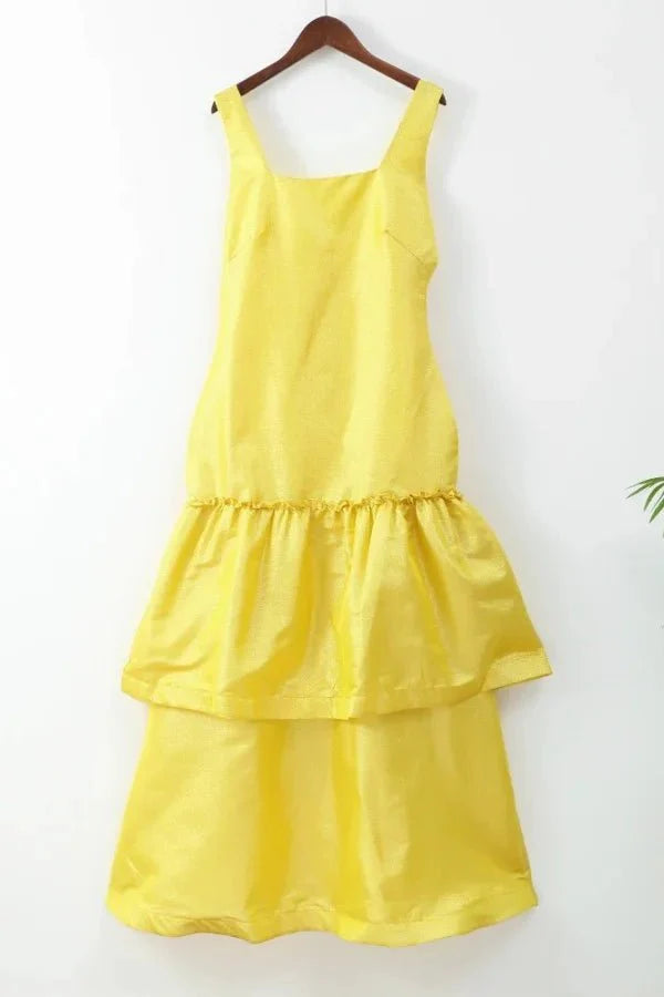 Model wearing the Kouvr Valeria canary yellow tiered ruffle maxi dress at an outdoor event