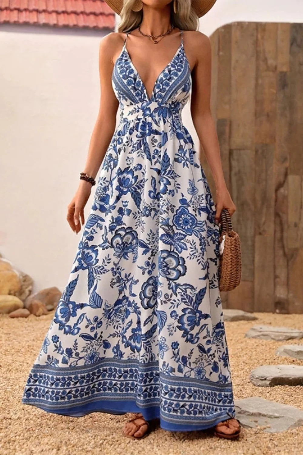 Woman walking in Kouvr Vanessa backless floral maxi dress showing criss-cross straps