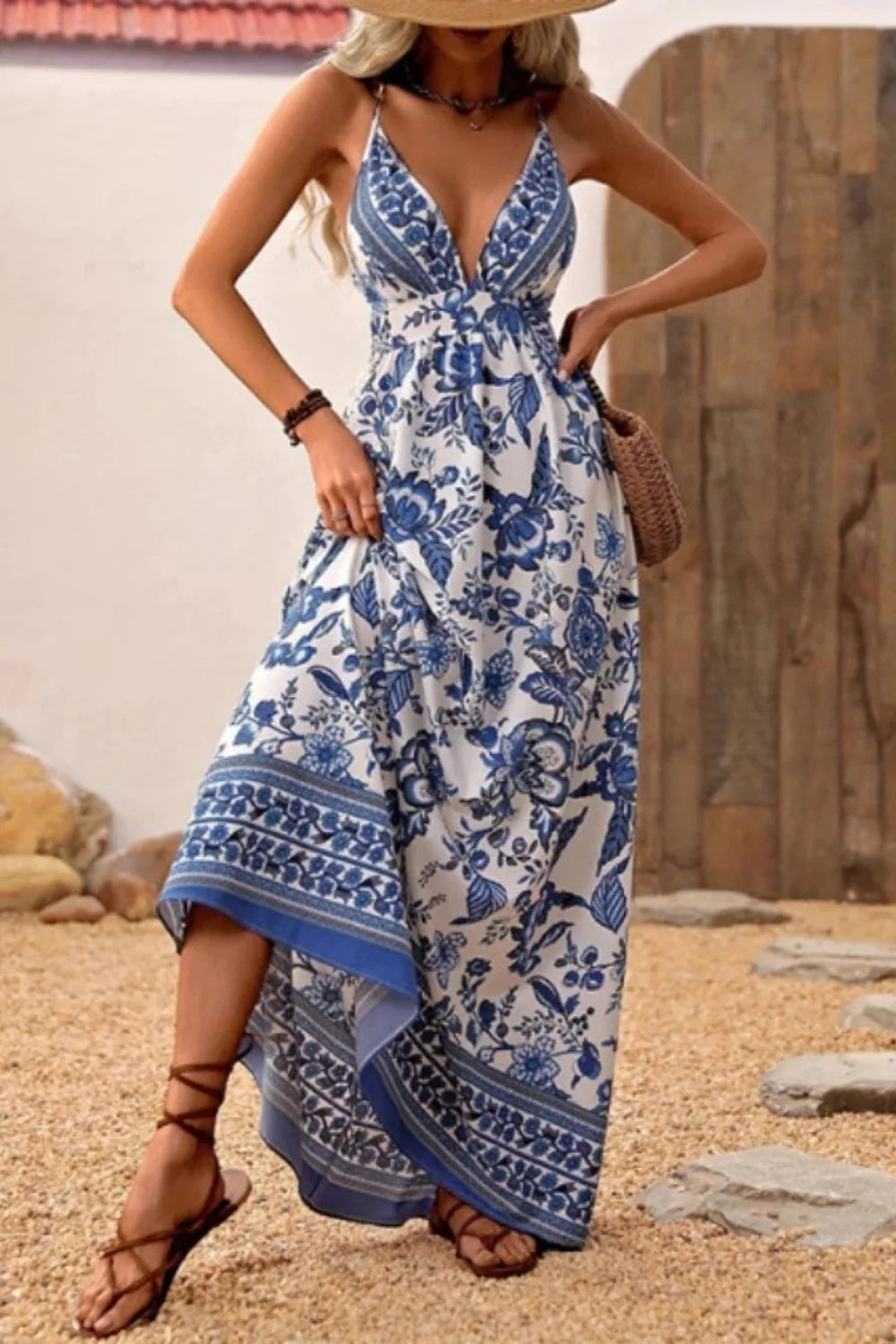 Woman walking in Kouvr Vanessa backless floral maxi dress showing criss-cross straps