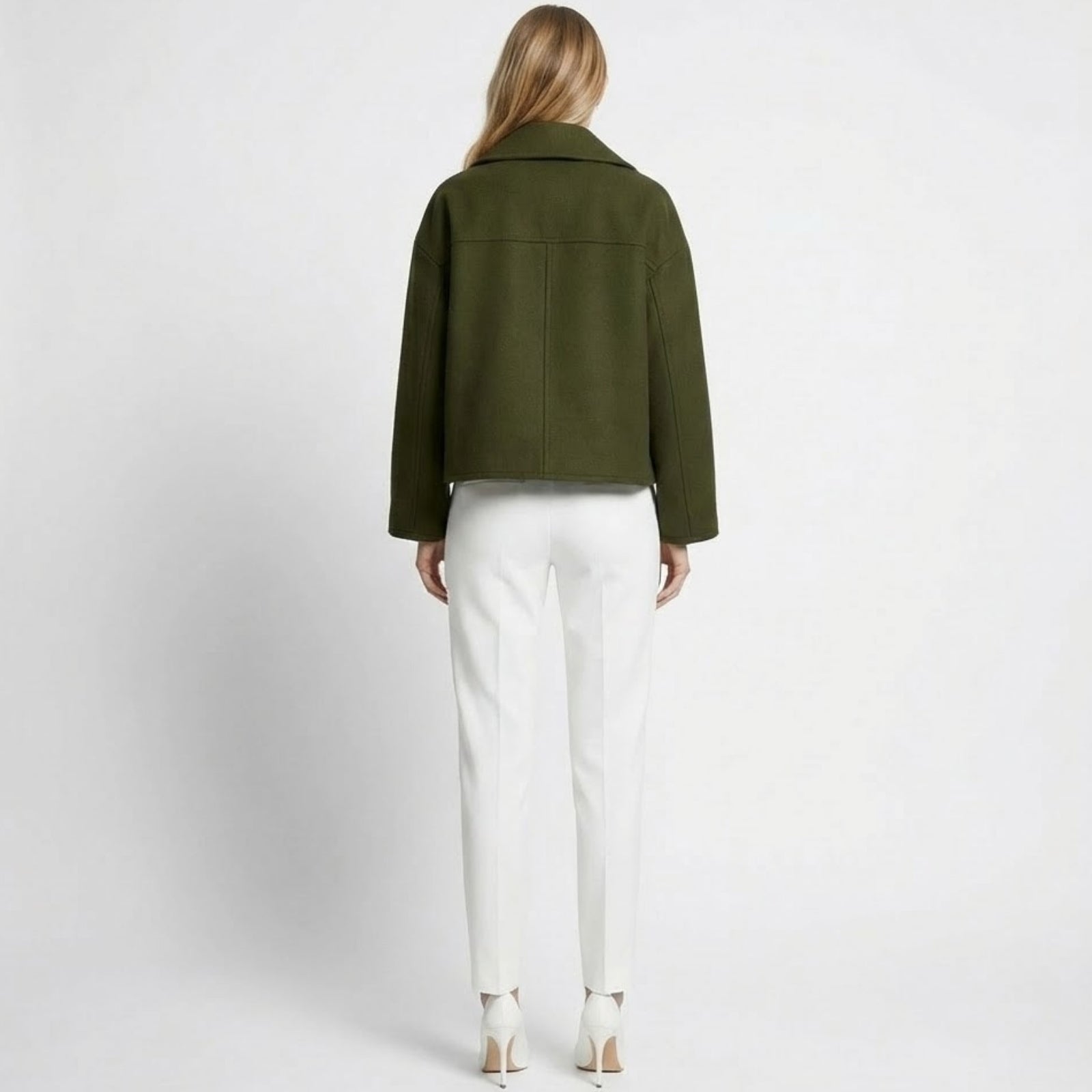 Back view of a model in the Kouvr dark green cropped wool peacoat, highlighting the clean seam details and wide collar.