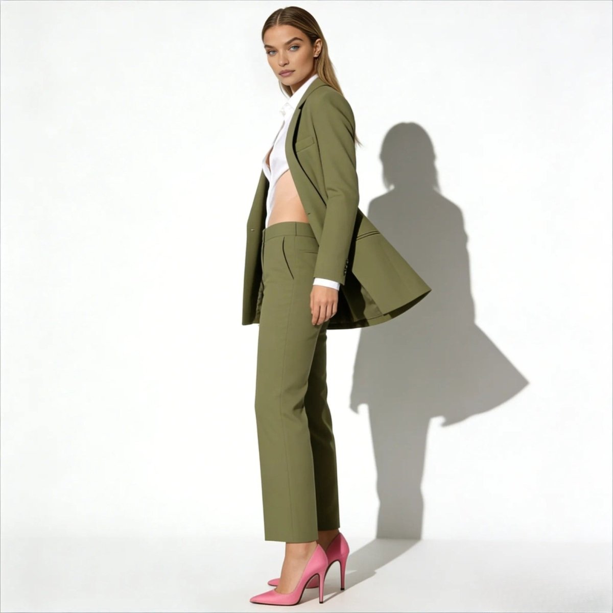 Side profile of a model showcasing the drape and relaxed fit of the Kouvr Fashion olive green power suit blazer and matching wide-leg pants.
