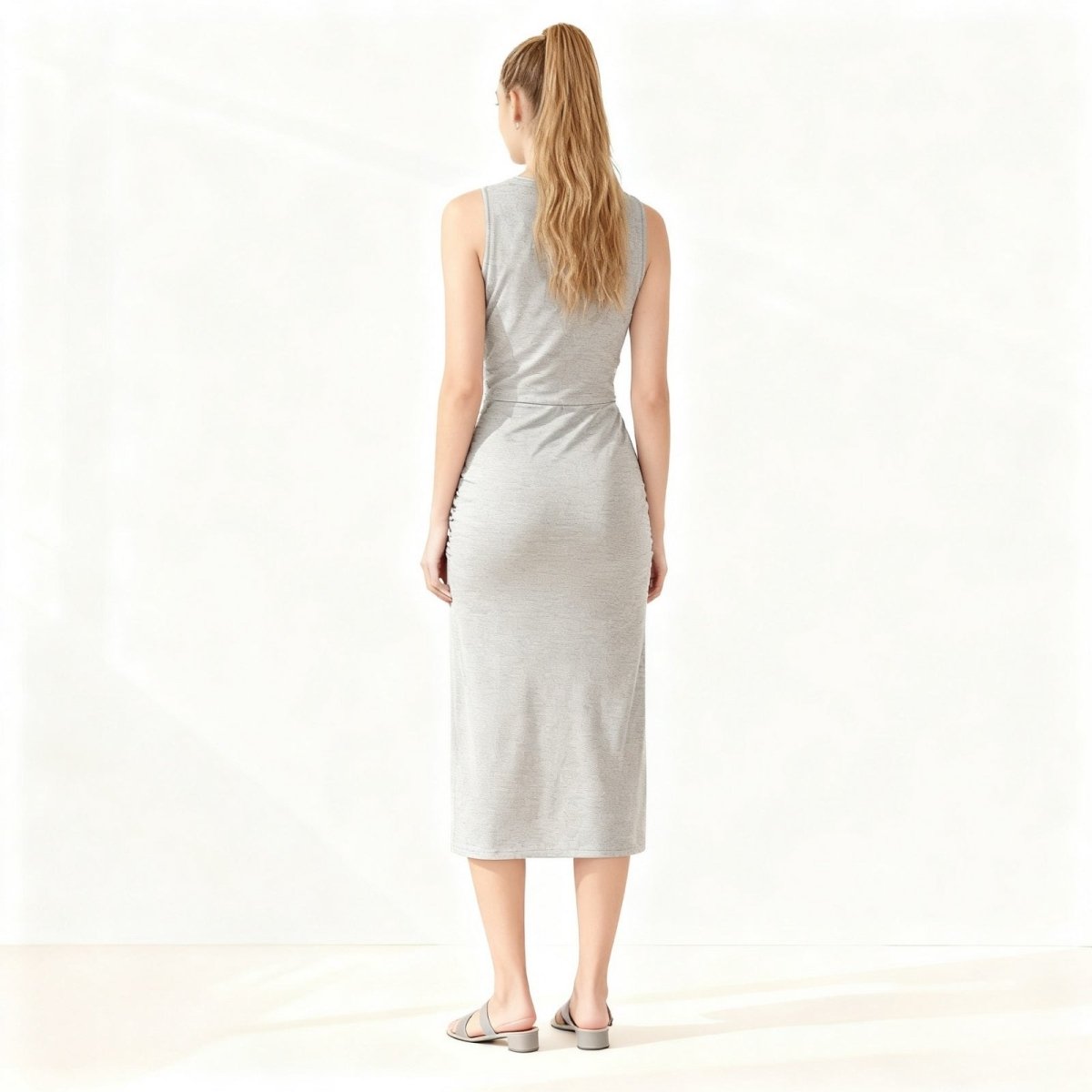 Woman wearing a grey Kouvr sleeveless dress on a white background