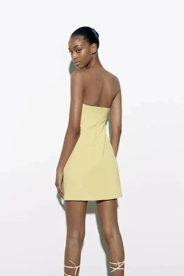 Model wearing the Kouvr Fashion yellow strapless cutout mini dress from the front