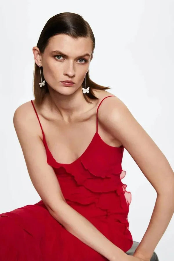 Model wearing the Kouvr Fashion Amor red ruffle maxi gown with an open back and side slit