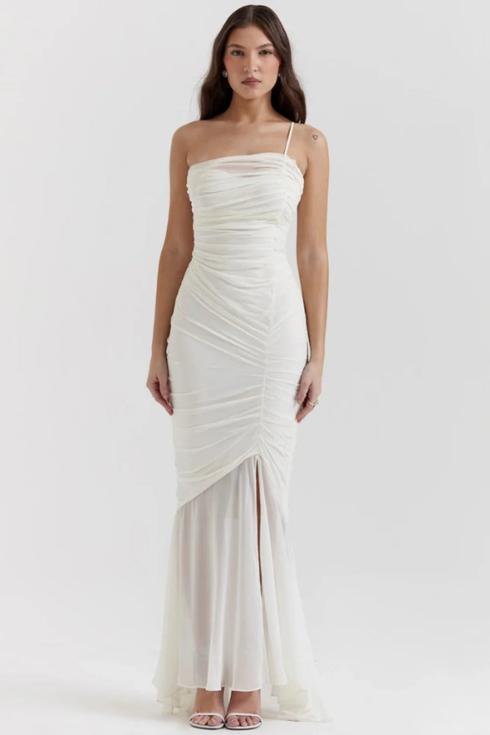 Model wearing the Kouvr Fashion Ruched white one-shoulder ruched maxi dress with a sheer mermaid hem and thigh-high slit