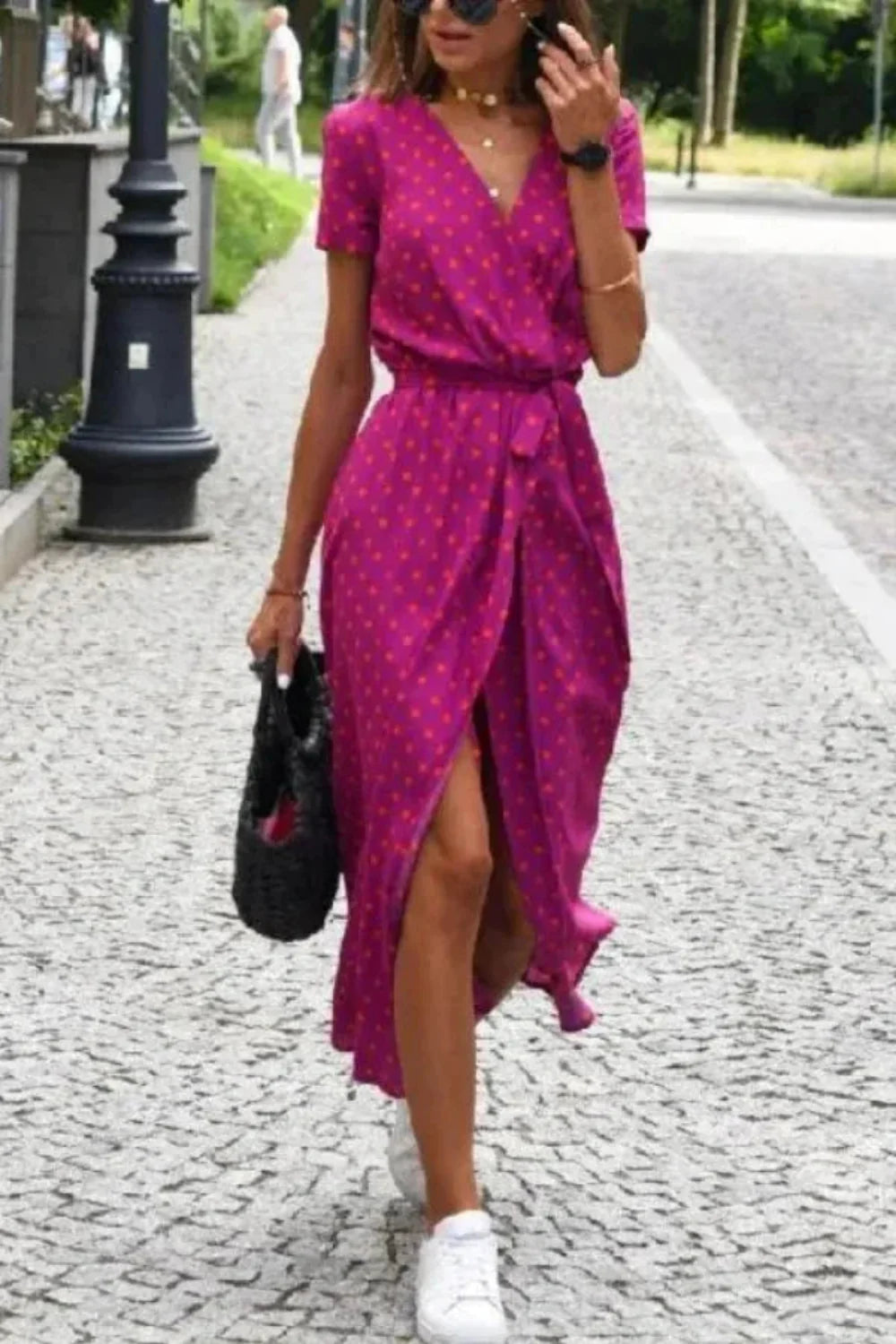 Model walking in the Aleia pink polka dot wrap dress.