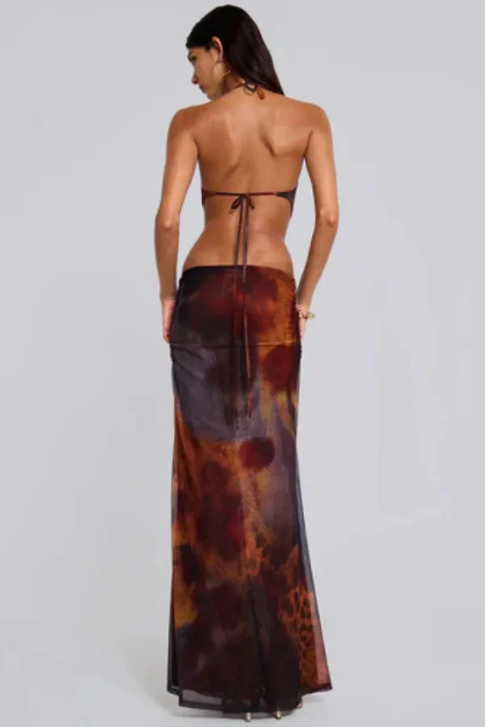 Model wearing the Kouvr Alexa brown leopard print cutout maxi dress with a halter neck and gold butterfly detail