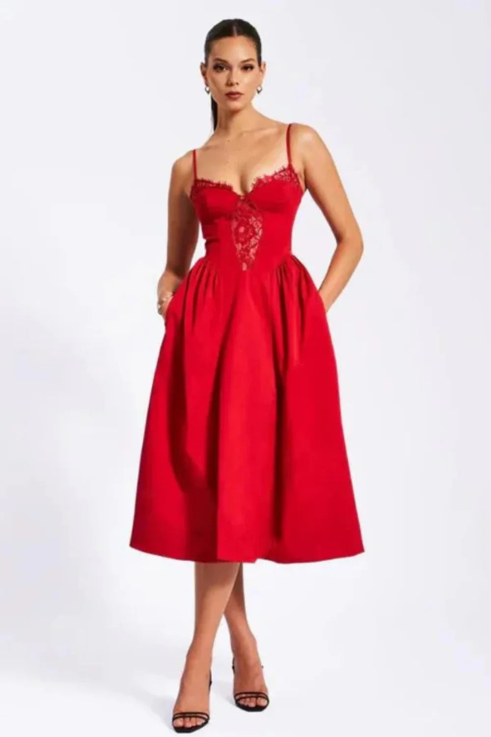 Model wearing Kouvr Amadi red corset midi dress with lace detail and hands in pockets