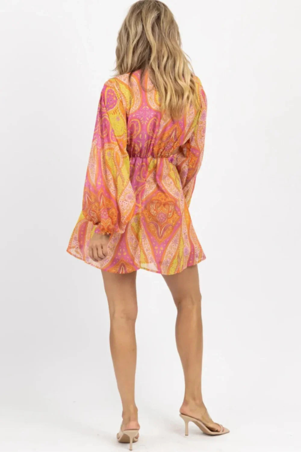 Model wearing Kouvr's long sleeve angelica cutout mini dress in orange