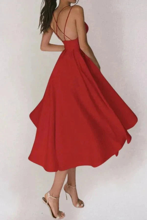 Woman wearing the Kouvr Aria red midi cocktail dress with a plunging neckline and open back.