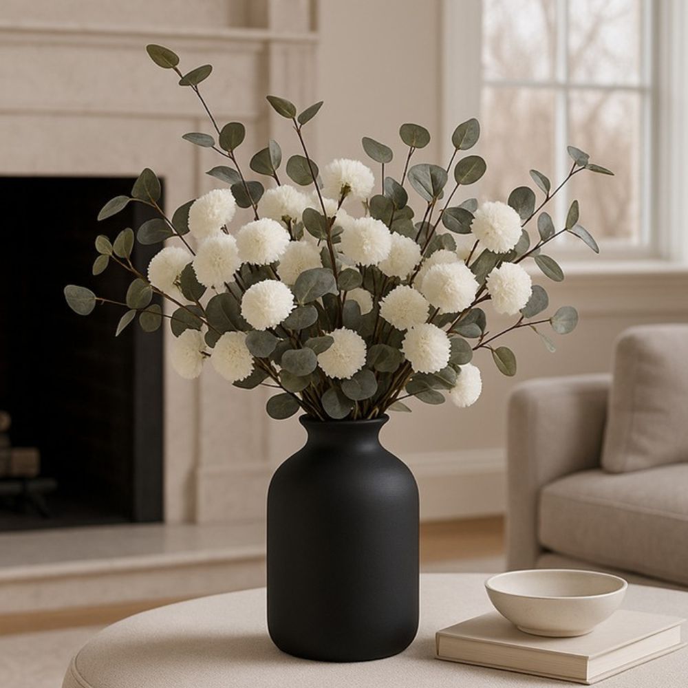 Kouvr Aspen Dream artificial flower arrangement with white pom poms and bleached eucalyptus in a modern matte black ceramic vase