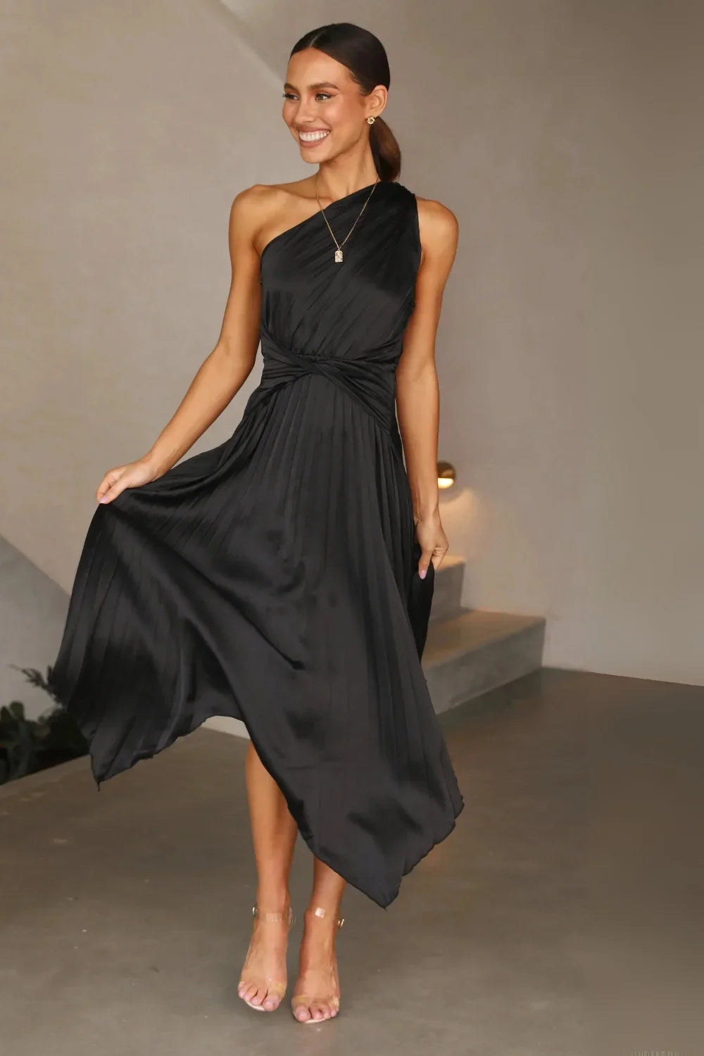 Model wearing the Kouvr Audrine one shoulder silk gown in black, showcasing its draped, asymmetrical design