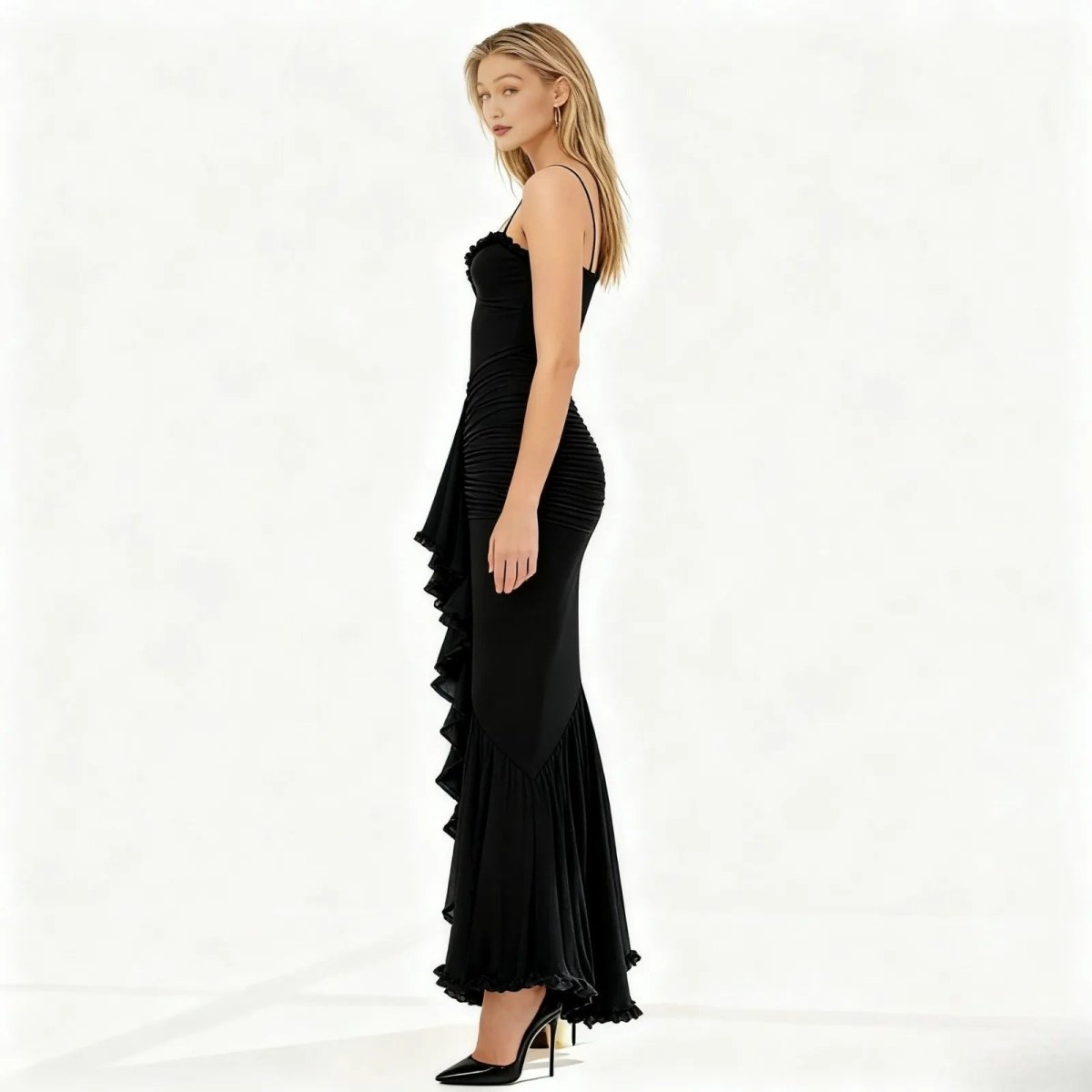 Woman wearing a black evening gown with ruffled details on a white background