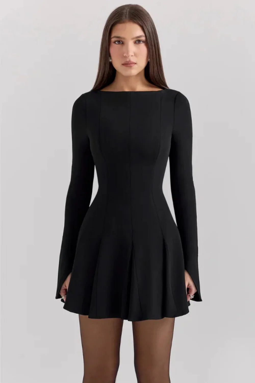 Model from behind wearing the Kouvr Fashion black long sleeve mini dress, showing the button details on the split cuffs