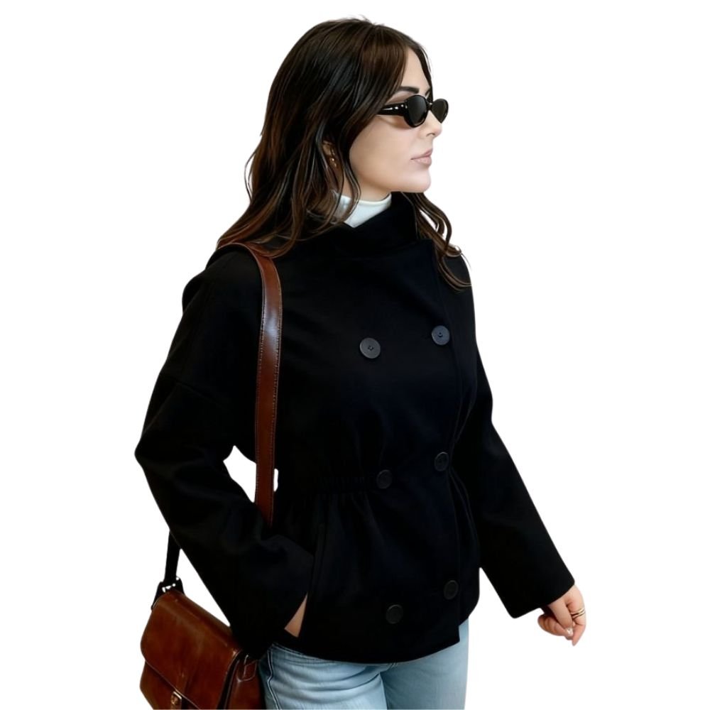 Side profile of a model wearing the Kouvr black wool jacket with the waist cinched, highlighting its versatile shape and wide sleeves.