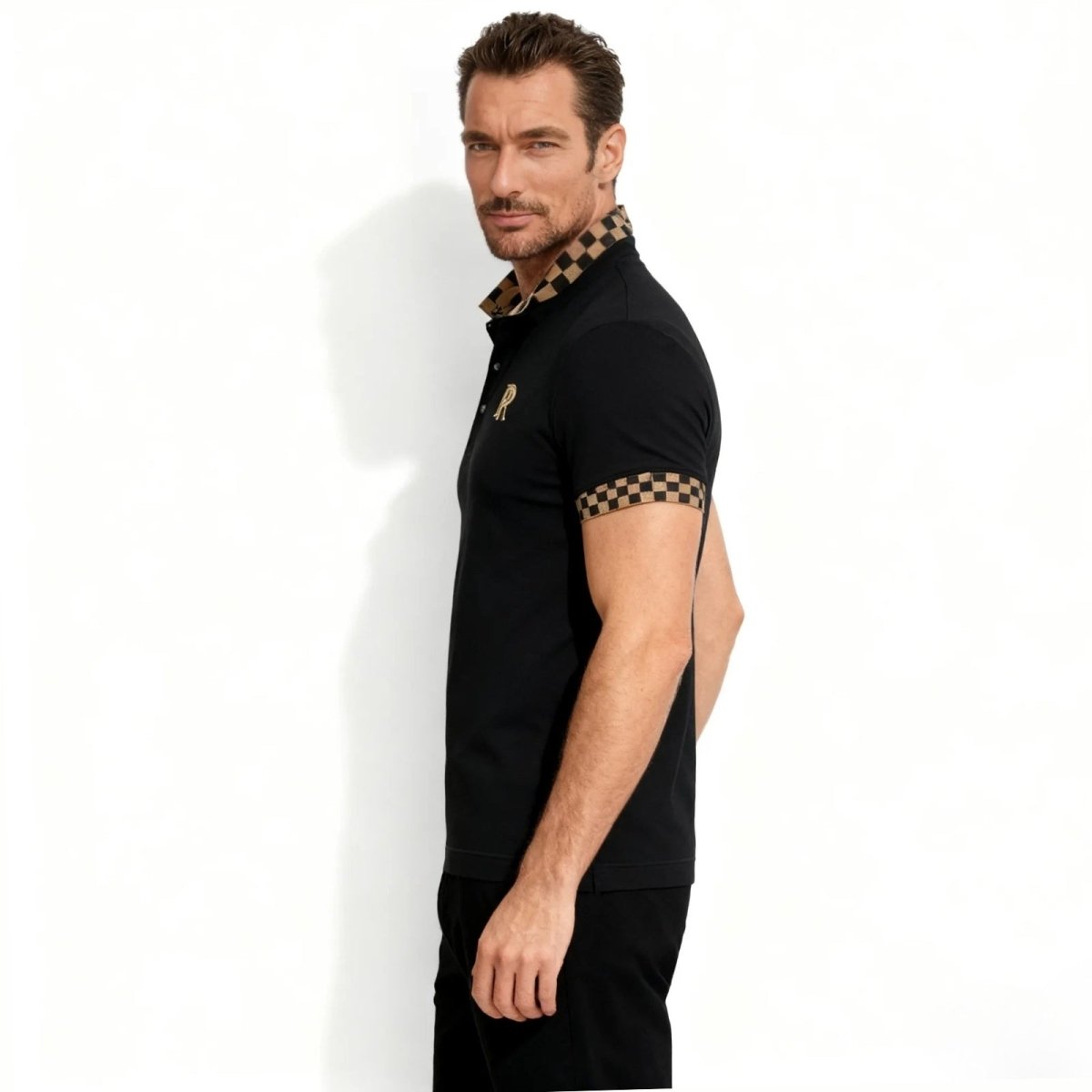 Side profile of a man wearing the Kouvr luxury black polo shirt, highlighting the athletic fit and the detailed checkered pattern on the collar.