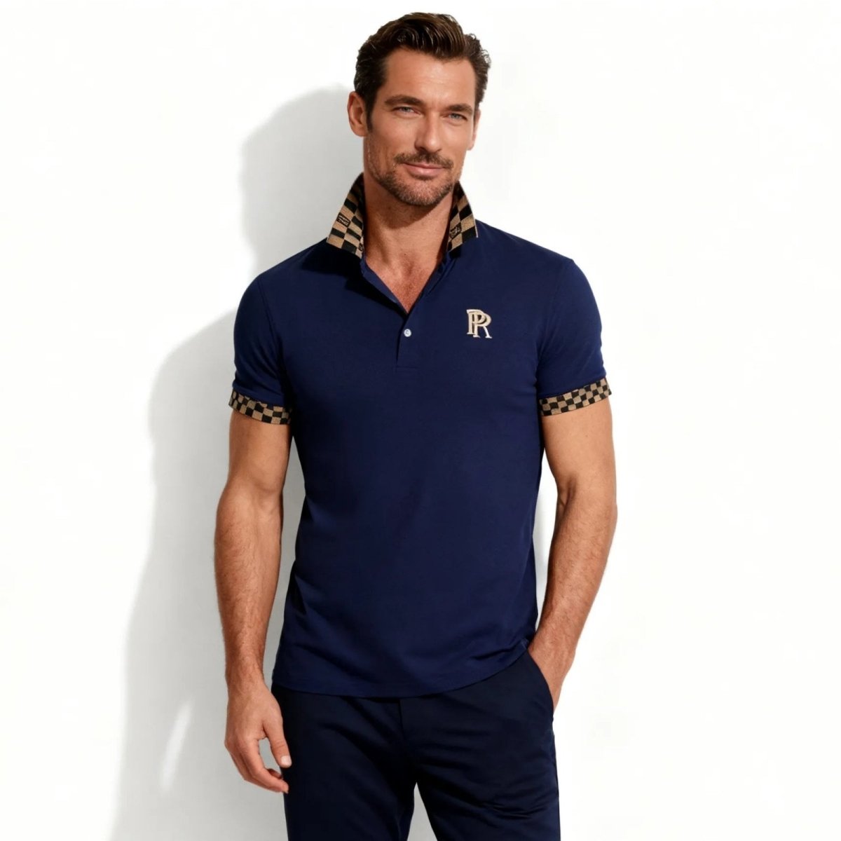 Model wearing the Kouvr Brent men's luxury navy blue polo shirt with a distinctive checkered pattern on the collar and sleeve cuffs, front view.