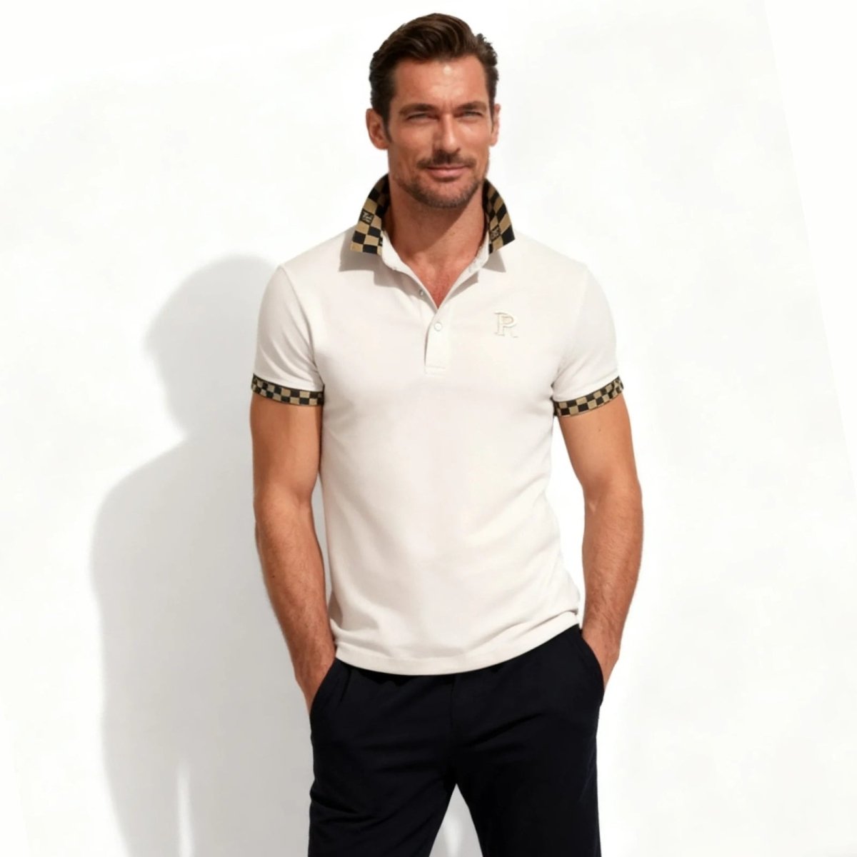 Model wearing the Kouvr Fashion men's designer polo shirt in pink with a black and gold checkered contrast collar.
