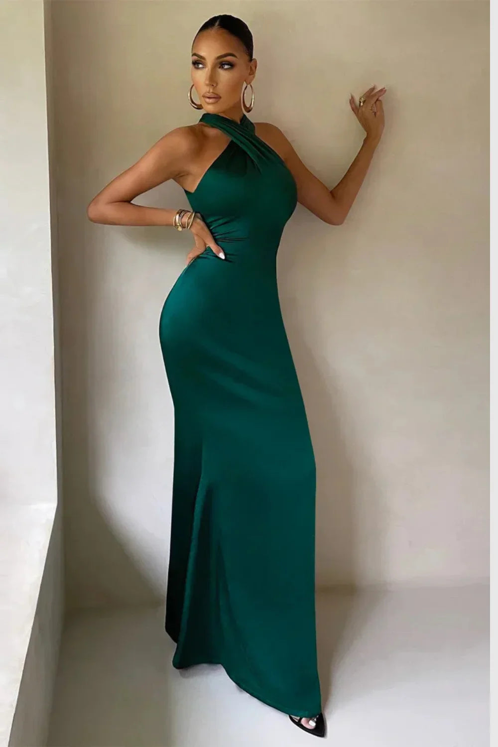 Model from the front wearing the Kouvr Camina emerald satin halter neck gown
