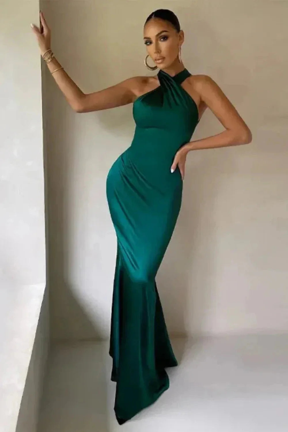 Model from the front wearing the Kouvr Camina emerald satin halter neck gown