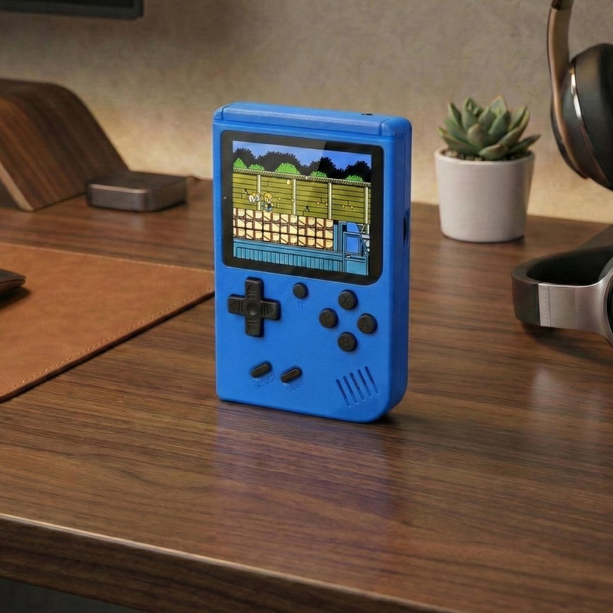 A standalone blue Kouvr handheld retro game console sitting upright on a wooden desk, showcasing its bright screen and classic button layout.