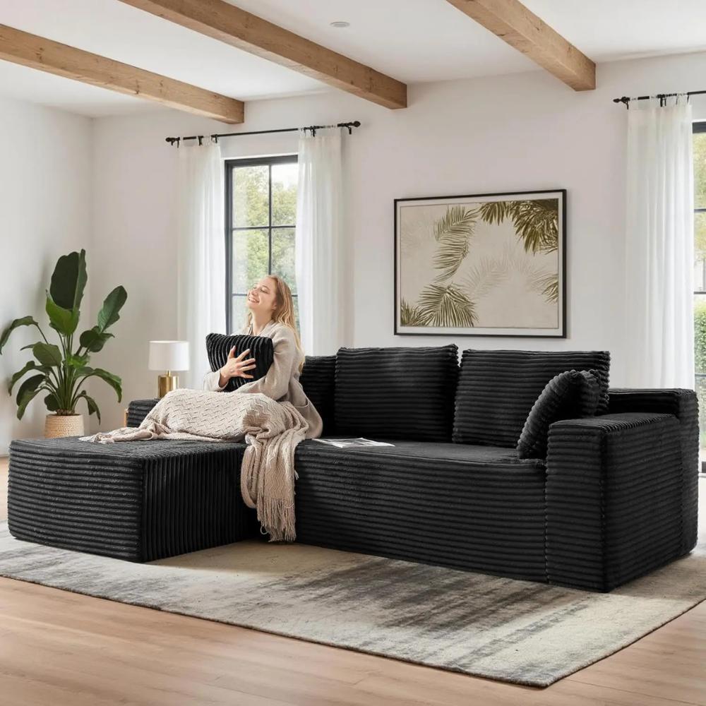 Woman relaxing on the Kouvr corduroy l-shaped cloud sofa in a modern grey living room