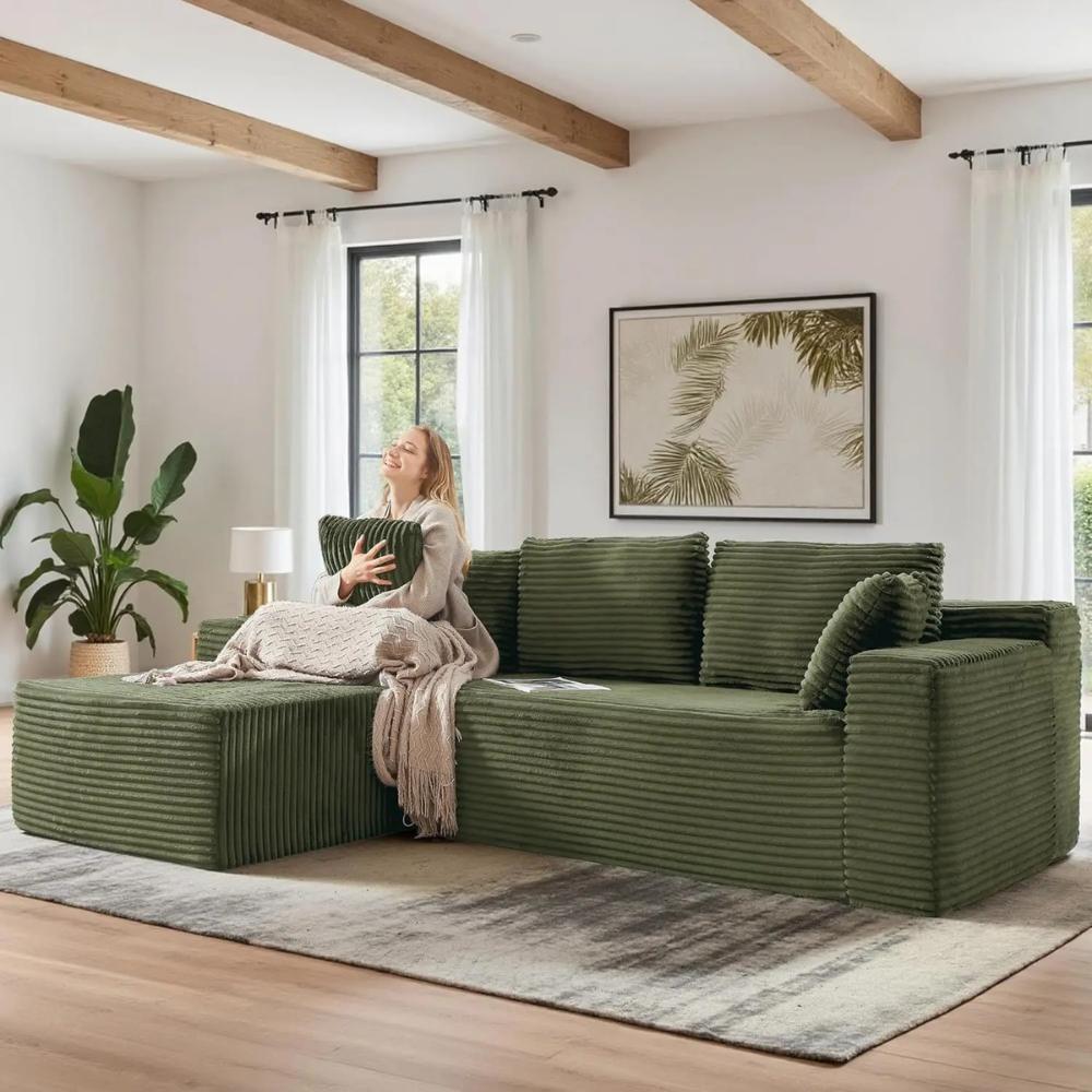 Woman relaxing on the Kouvr corduroy l-shaped cloud sofa in a modern grey living room