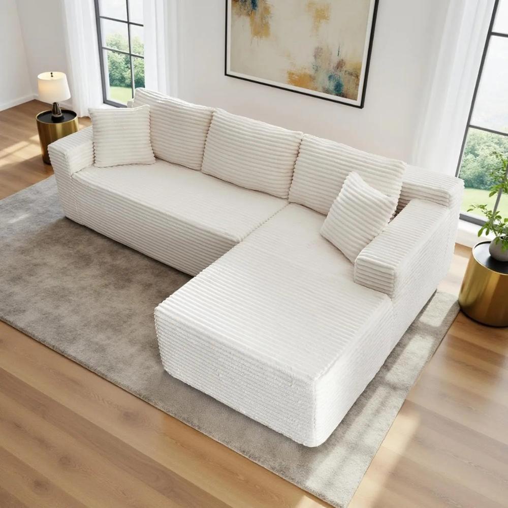 Woman relaxing on the Kouvr corduroy l-shaped cloud sofa in a modern grey living room