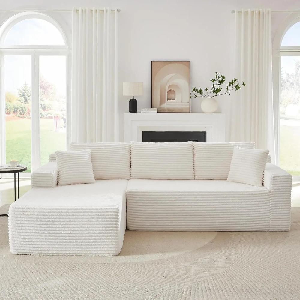 Woman relaxing on the Kouvr corduroy l-shaped cloud sofa in a modern grey living room