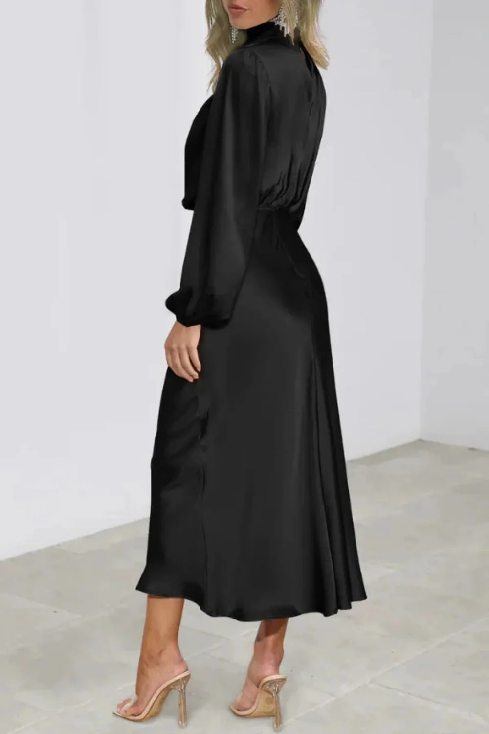 Model viewed from the front wearing the Kouvr black satin long sleeve cowl neck midi dress