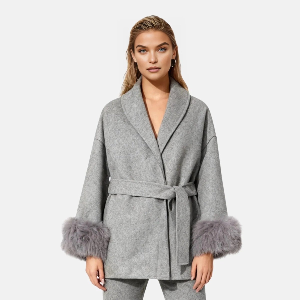 Woman wearing a gray robe with fur cuffs on a white background