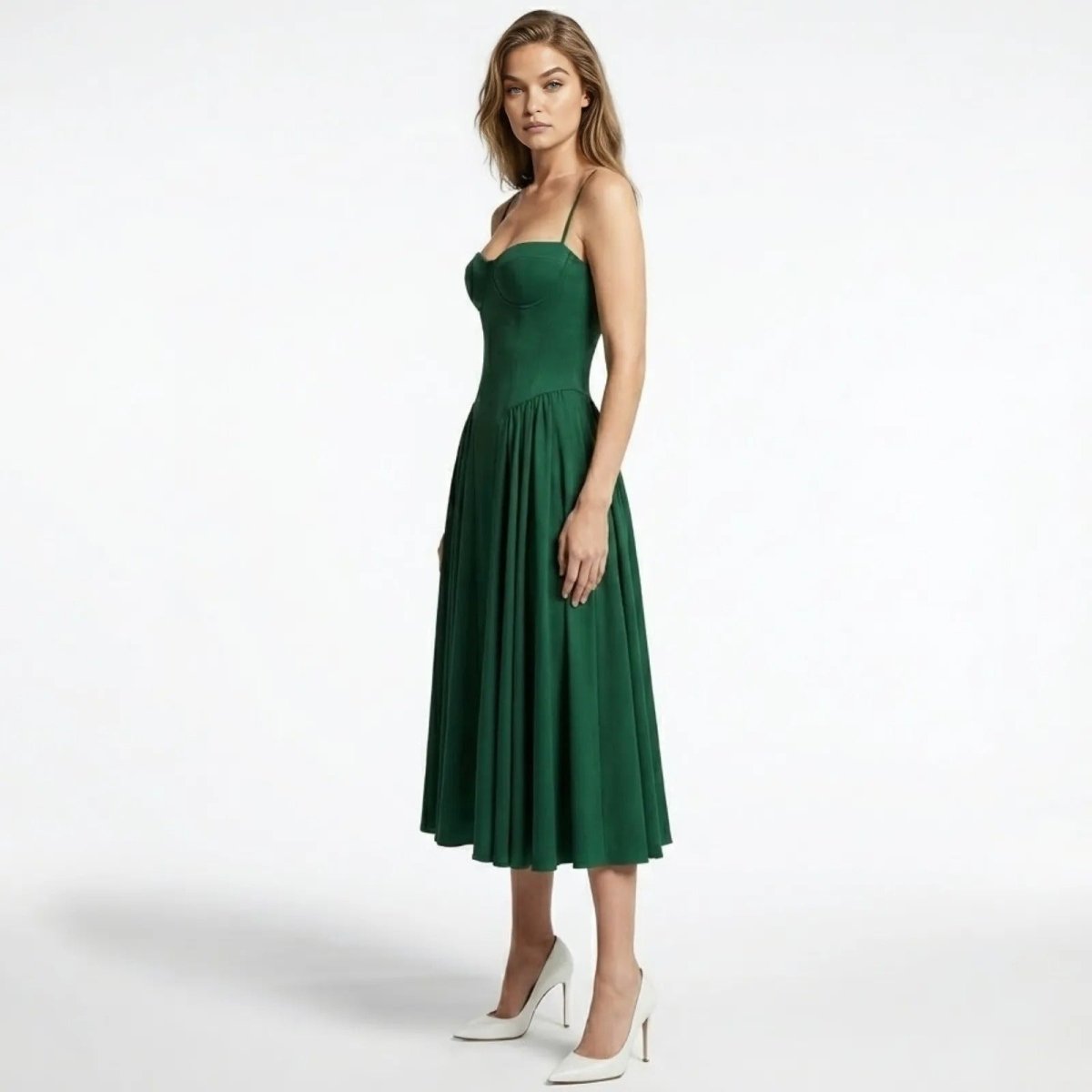 Side profile of a model in the Kouvr Evdokia emerald green formal dress, showing the fitted waist and drape of the midi skirt.
