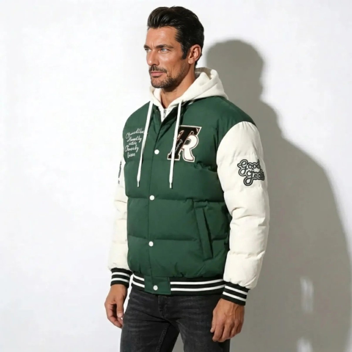 Side profile of a man in the green Kouvr Puffer Letterman Jacket, highlighting the padded white sleeves with 'Good Vibes' patch.