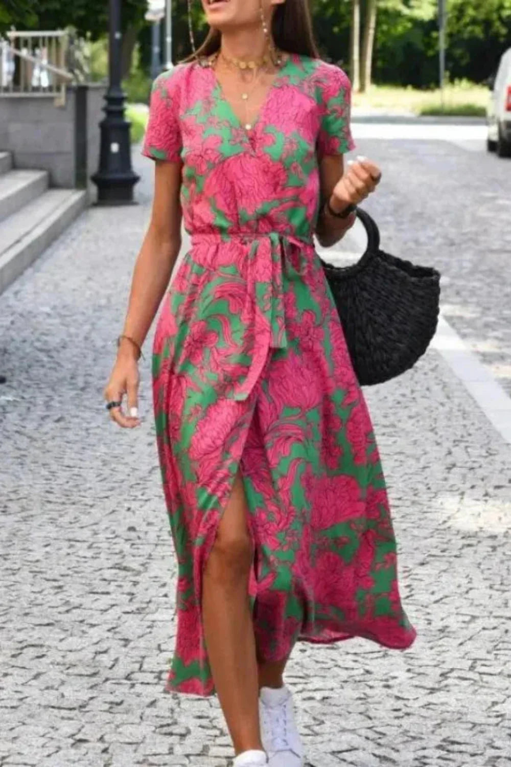 Model walking in the Aleia pink and green floral wrap midi dress.