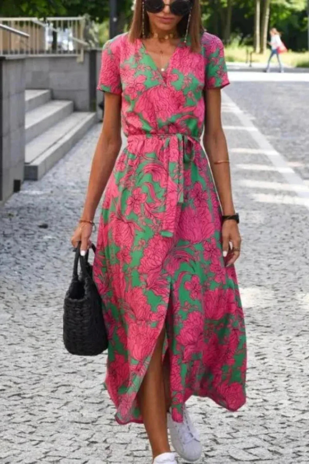 Full-length lifestyle image of the Aleia floral midi dress styled with white sneakers and a black bag.