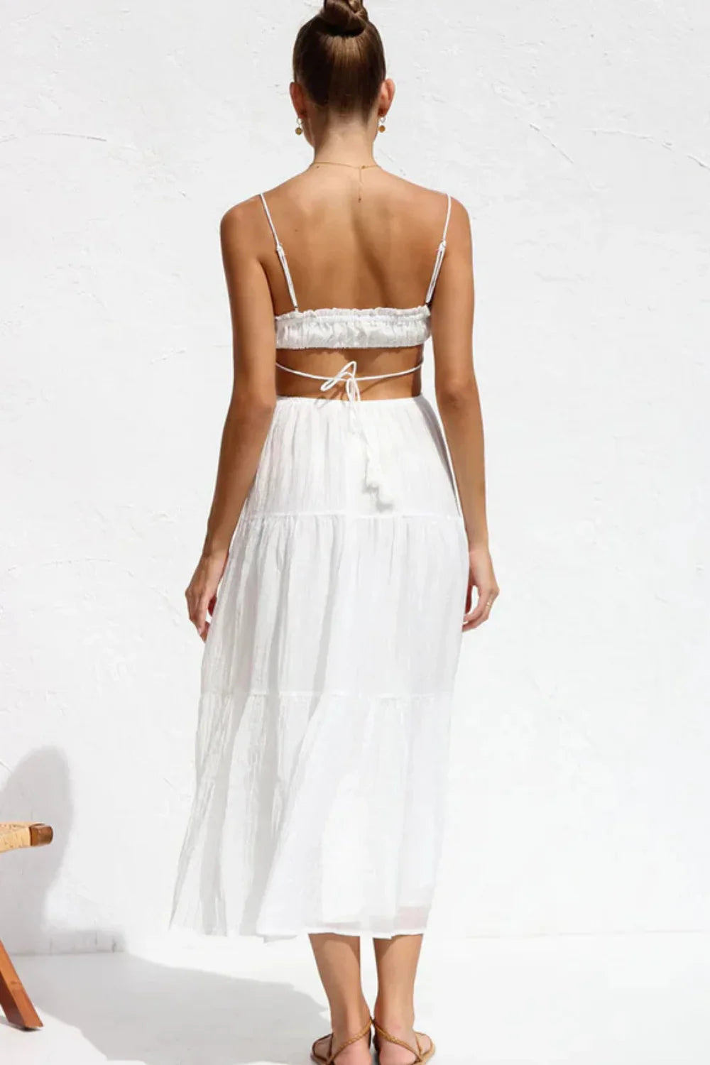 Back view of the Amelia white backless maxi dress by Kouvr, showing the open back and tie details.