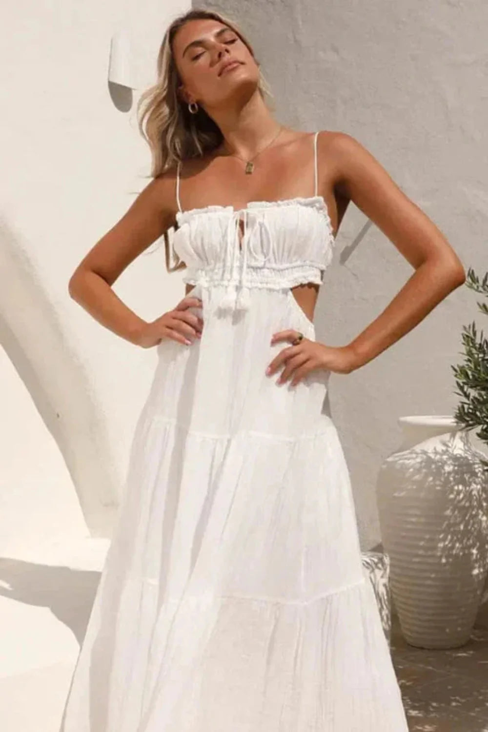 Model wearing the Amelia white cutout tiered maxi dress by Kouvr, front view.
