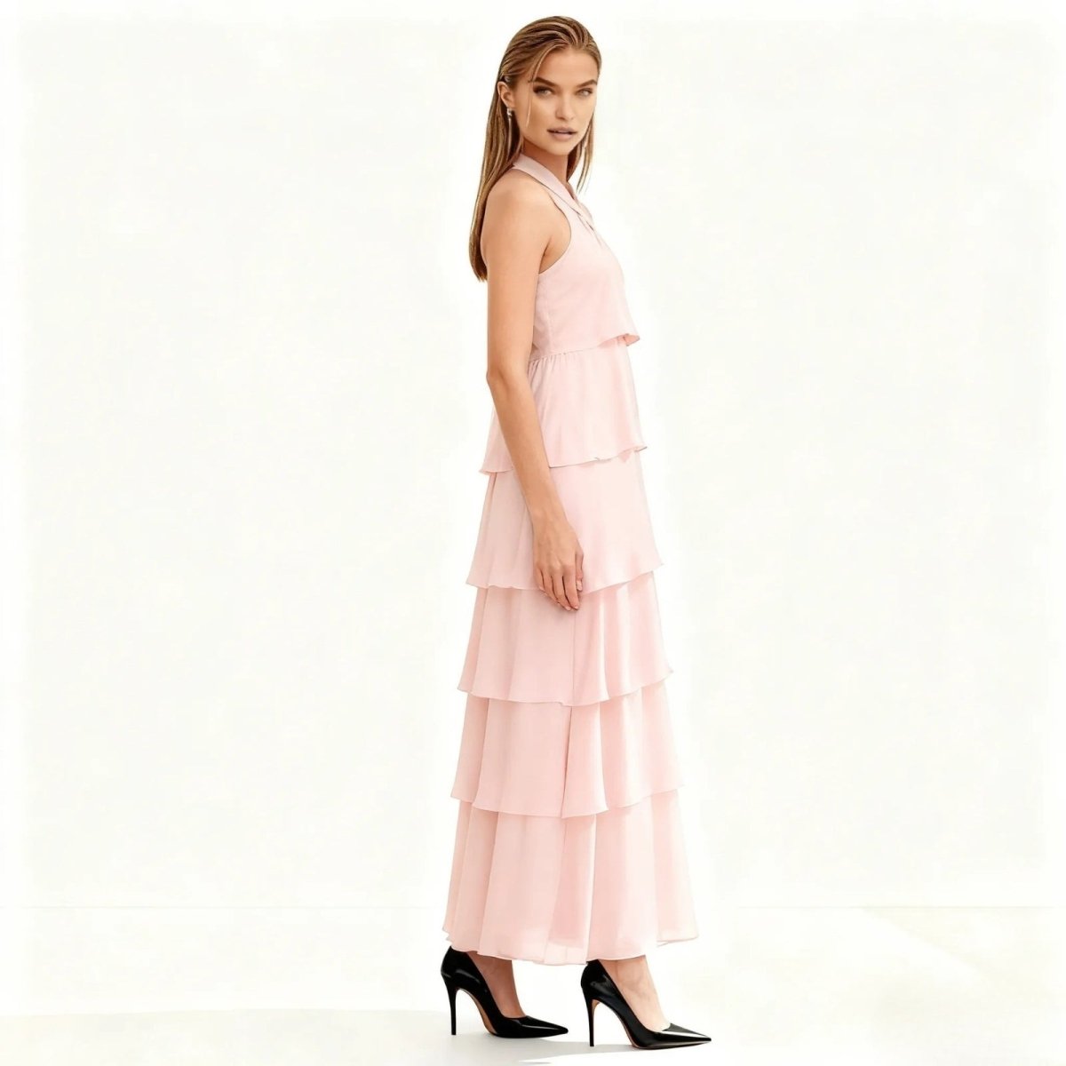 Woman wearing a pink Kouvr tiered dress on a white background