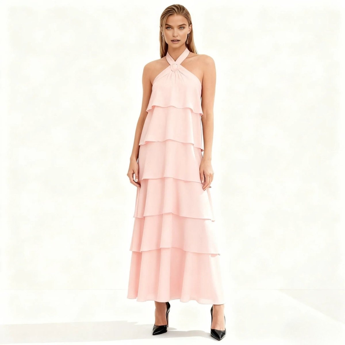 Woman wearing a pink Kouvr tiered dress on a white background