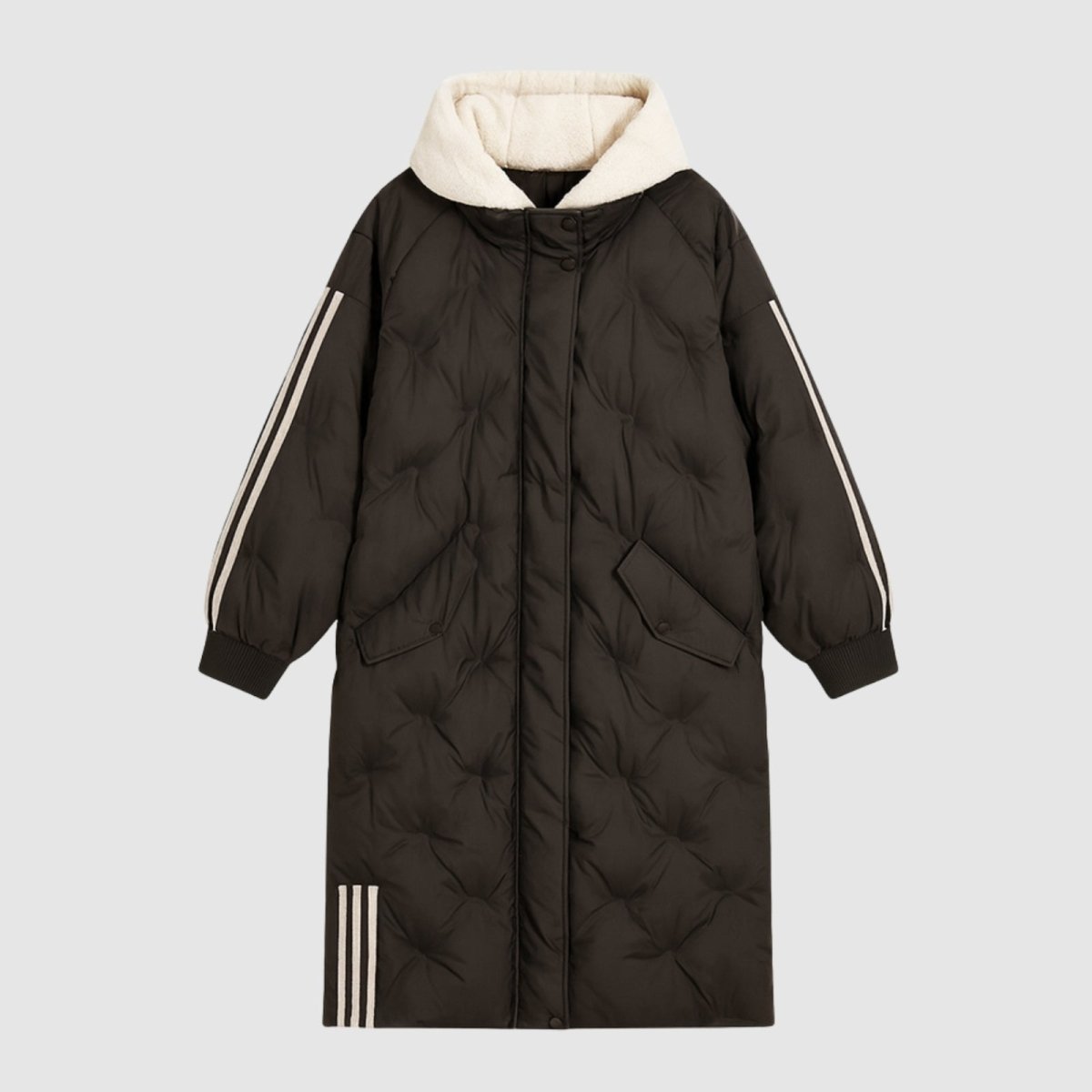 Flat lay of the Kouvr Arianne long puffer coat in black, showing the diamond-quilted texture, cream sherpa hood, and stripe details on sleeves and hem.