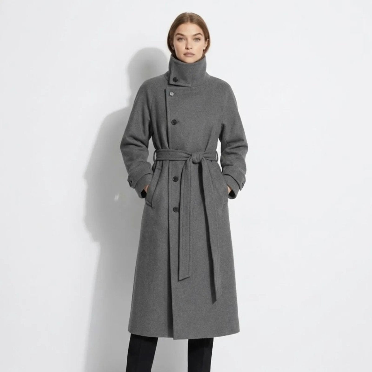 Model wearing the grey Kouvr Fashion Ashley&nbsp; funnel neck wool coat with the belt tied, showcasing the asymmetrical button closure and long silhouette.