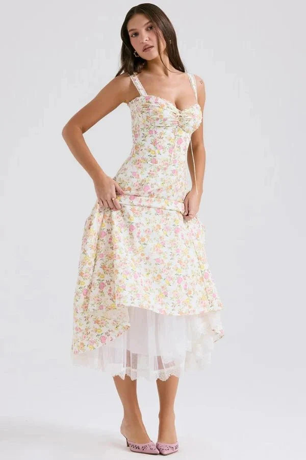 Model wearing Kouvr Fashion Aviva floral corset midi dress in white with pink and yellow flowers, showing the lace-up bustier and A-line skirt